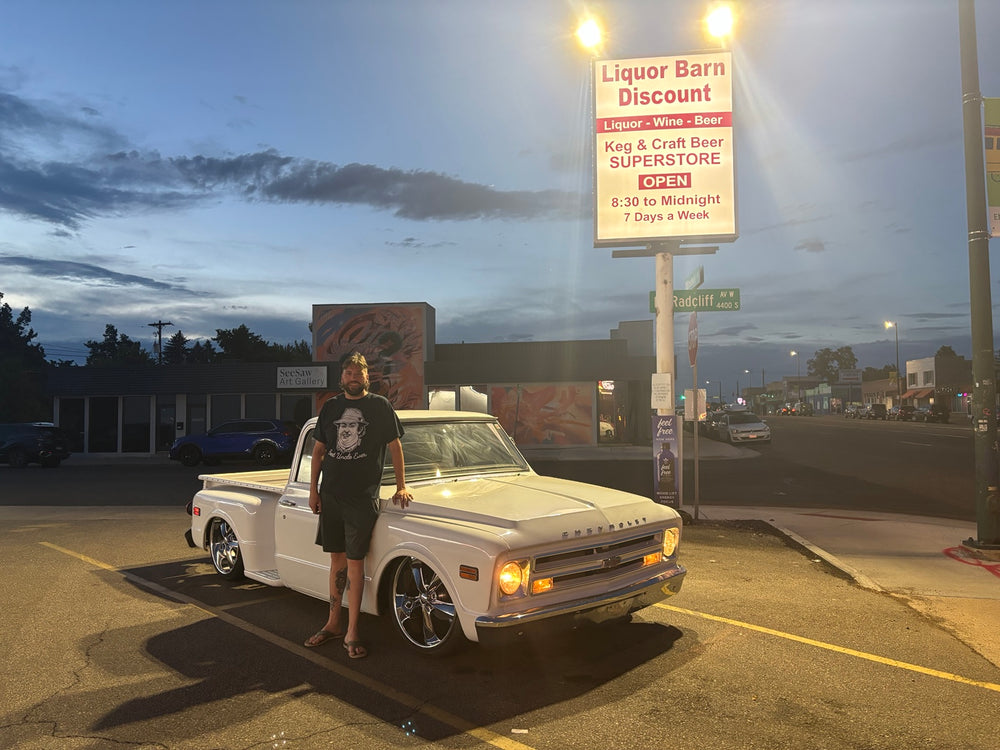 Evening photo of the white 1968 Chevrolet C10 Stepside with a person standing beside the truck.