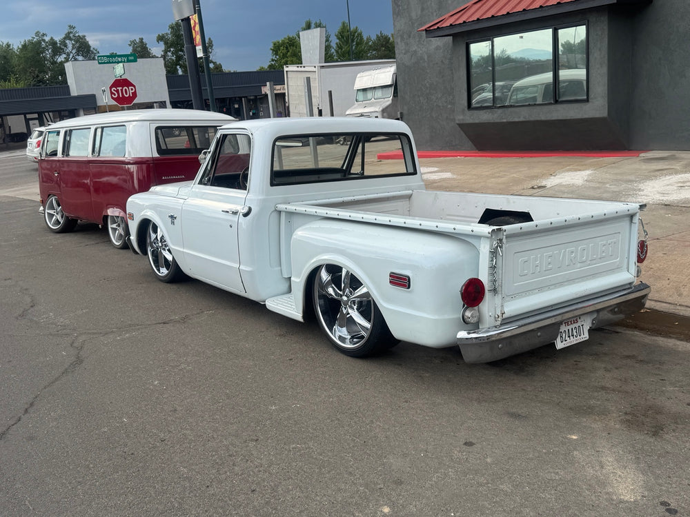 Rear three-quarter view of the white 1968 Chevrolet C10 Stepside, showing Chevrolet tailgate, chrome bumper and lowered stance.