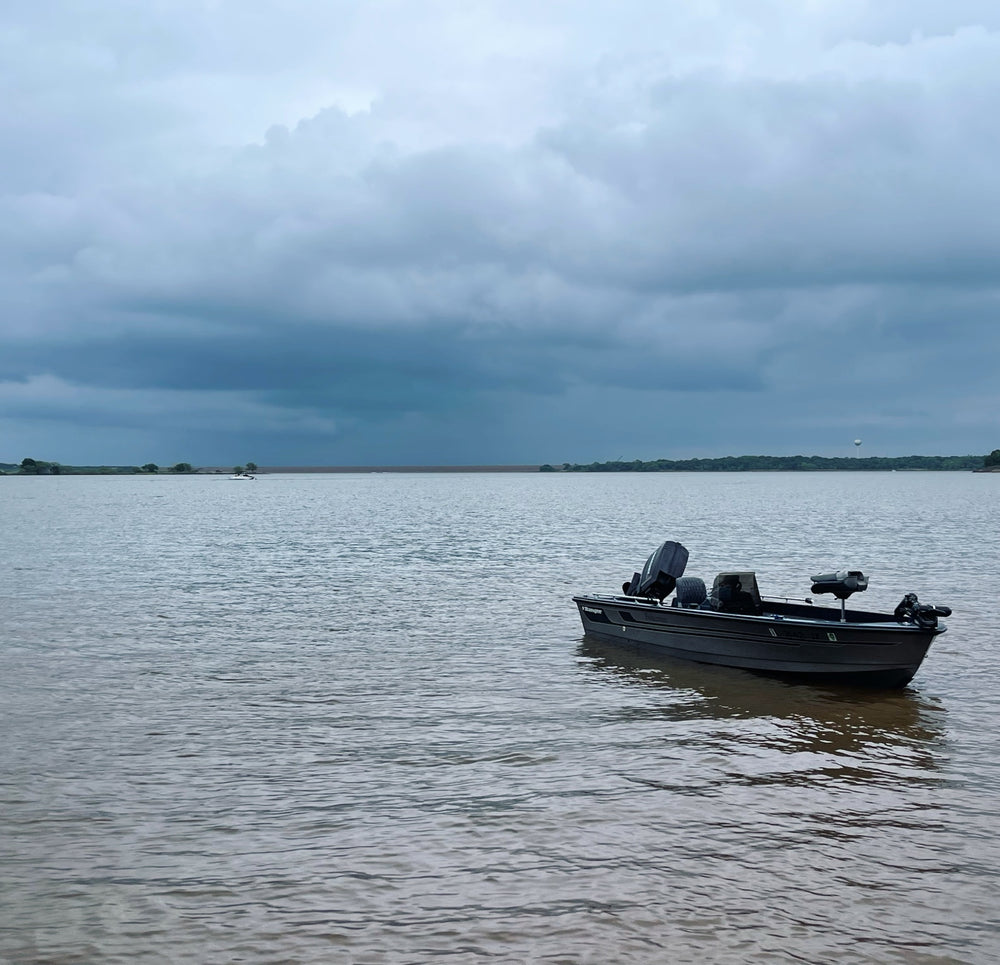 Second lake view of the 1990 Ranger Fisherman showing the fishing deck, center console and Mercury outboard.