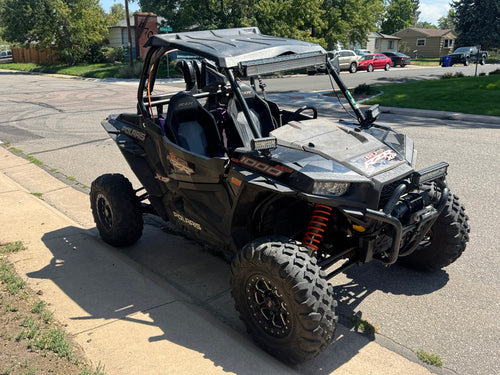 2018 Polaris RZR XP 1000 High Lifter front three-quarter view with roof, LED lights, winch and orange suspension springs.
