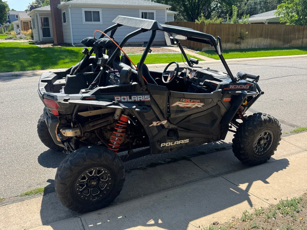 Rear three-quarter view of the 2018 Polaris RZR XP 1000 High Lifter showing raised intake tubes, roof and rear suspension.